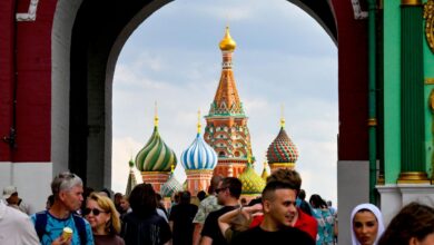 Туристы рассматривают матрешки на фоне северного сияния